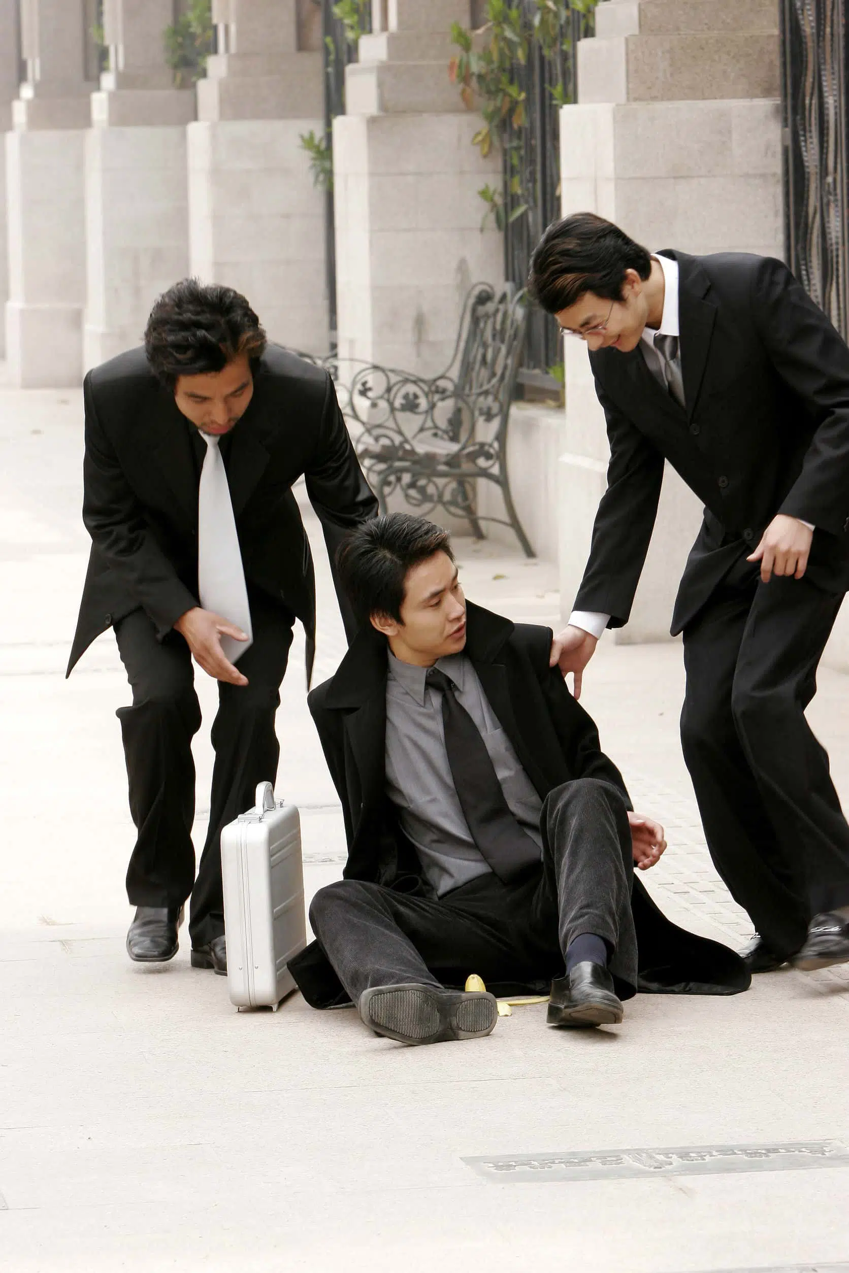 Image of two men helping a third man up after a fall
