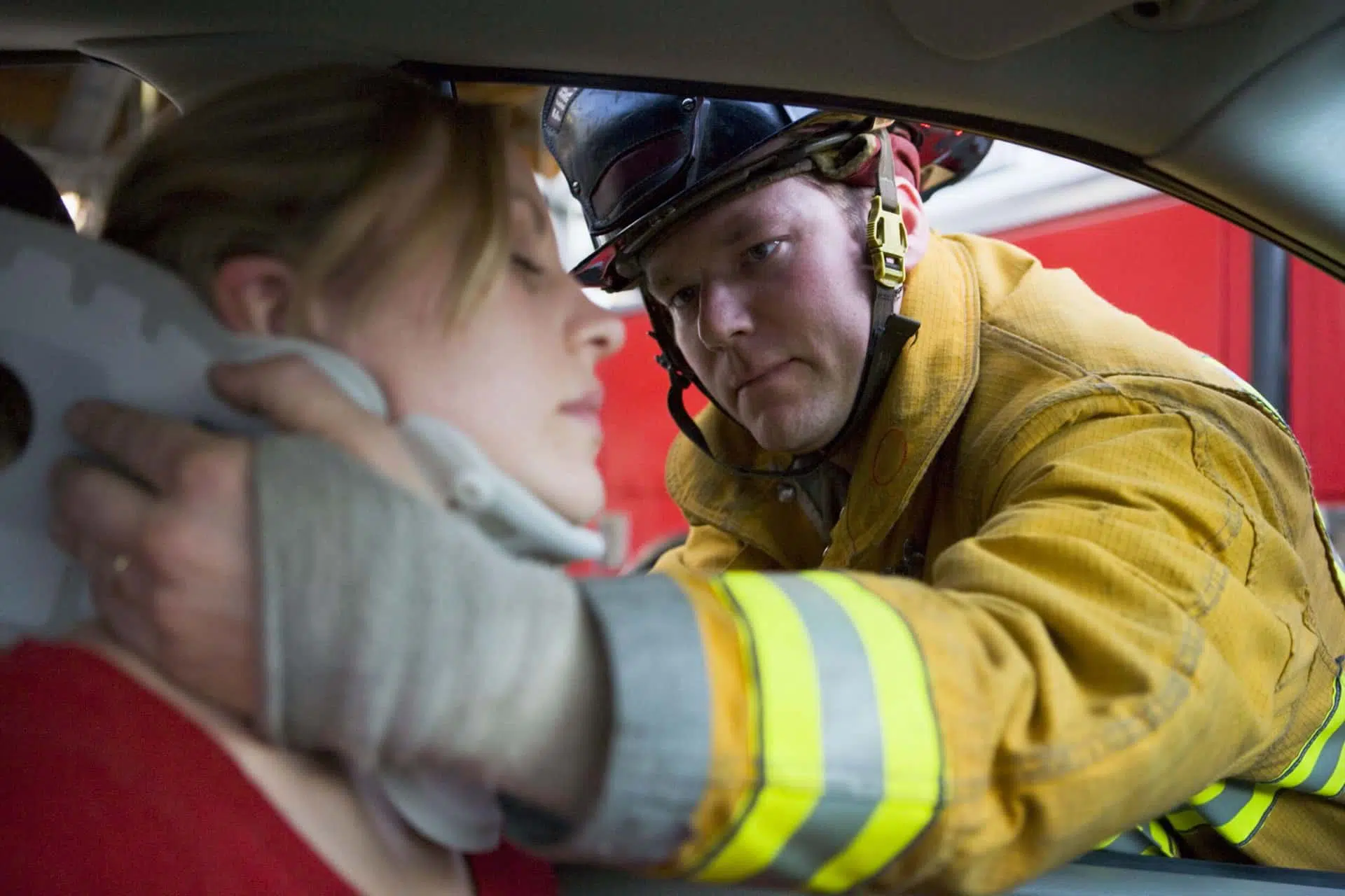 Fireman putting neckbrace on woman injured in an auto accident